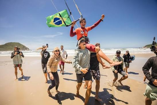 Gabriel Benetton comemorando o título mundial carregado pela equipe, com a bandeira do Brasil
